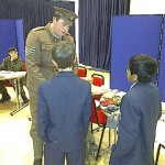 A man in WW1 soldier uniform talks to school children